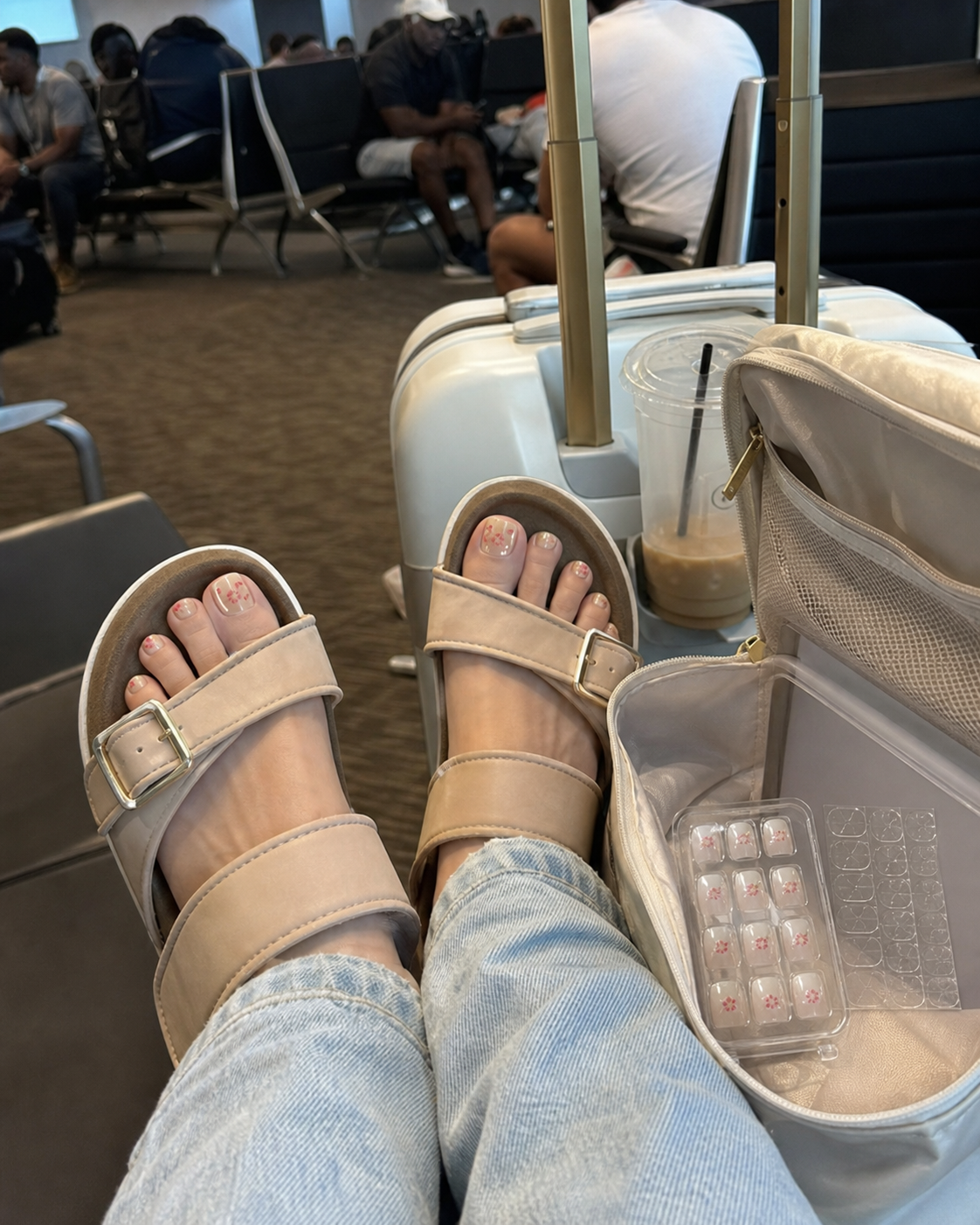 Airport gate phone photo of floral press-on nails and product tray